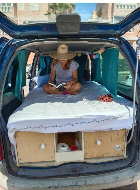 Vista trasera de la camper con la cama y el módulo de cocina