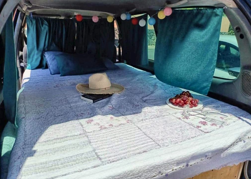Cama doble hecha con ropa de cama y almohadas